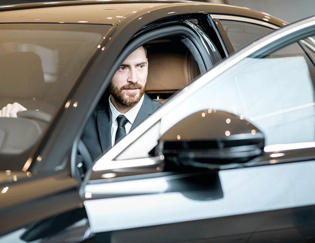 A friendly and professional Limousine Plus chauffeur opening the door of a luxury vehicle, ready to provide excellent service in Istanbul.