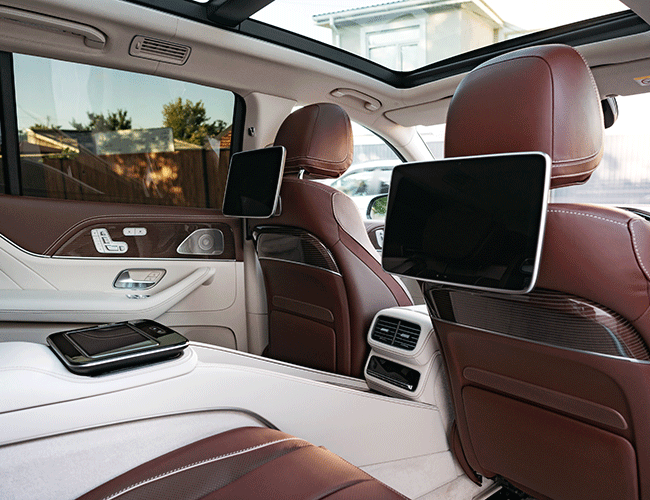 The luxurious interior of a Mercedes-Benz with rear-seat entertainment screens, showcasing the premium features of our Istanbul chauffeured car rental service.