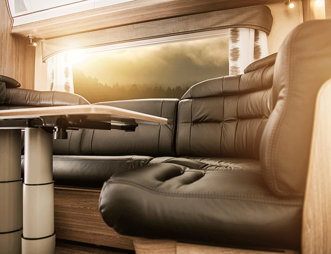 Spacious and luxurious interior of a VIP shuttle or caravan with leather seats and a table, ideal for group airport transfers in Istanbul.