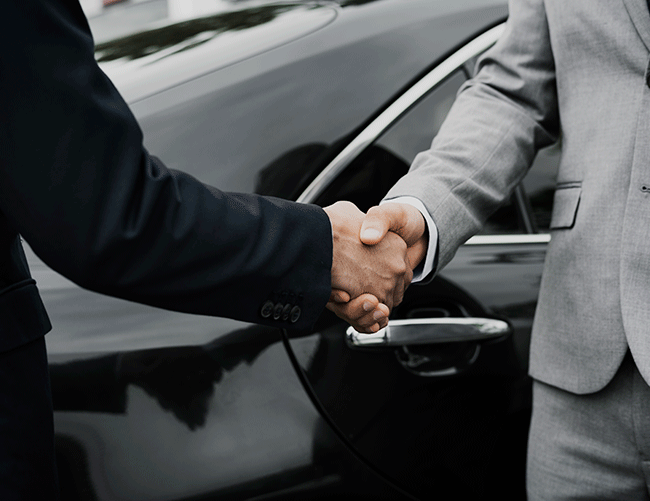 Two businessmen shaking hands in front of a luxury vehicle, symbolizing a trusted B2B transportation partnership with Limousine Plus in Istanbul.