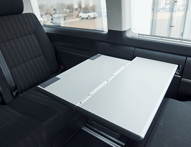 Interior of a Mercedes Vito VIP transfer vehicle with a foldable work table